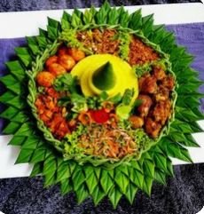 Nasi tumpeng tradisional yang lezat, disajikan dengan lauk lengkap seperti ayam goreng, perkedel, urap, telur, dan sambal.